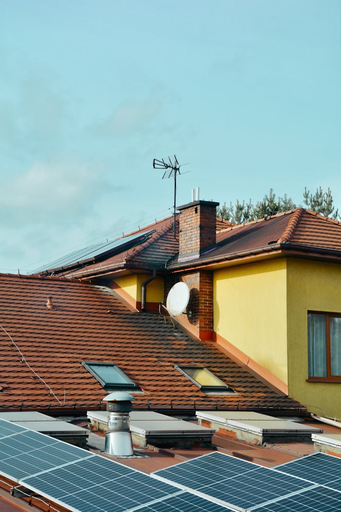 services-02 Yellow building with solar panels and antennas on rooftop in Poland. Eco-friendly technology.