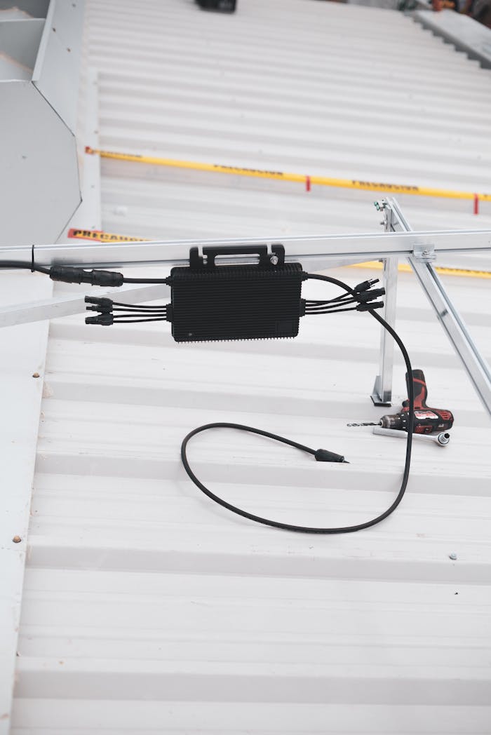 gallery-6 Close-up of solar charge controller installation with cables on a metal roof.